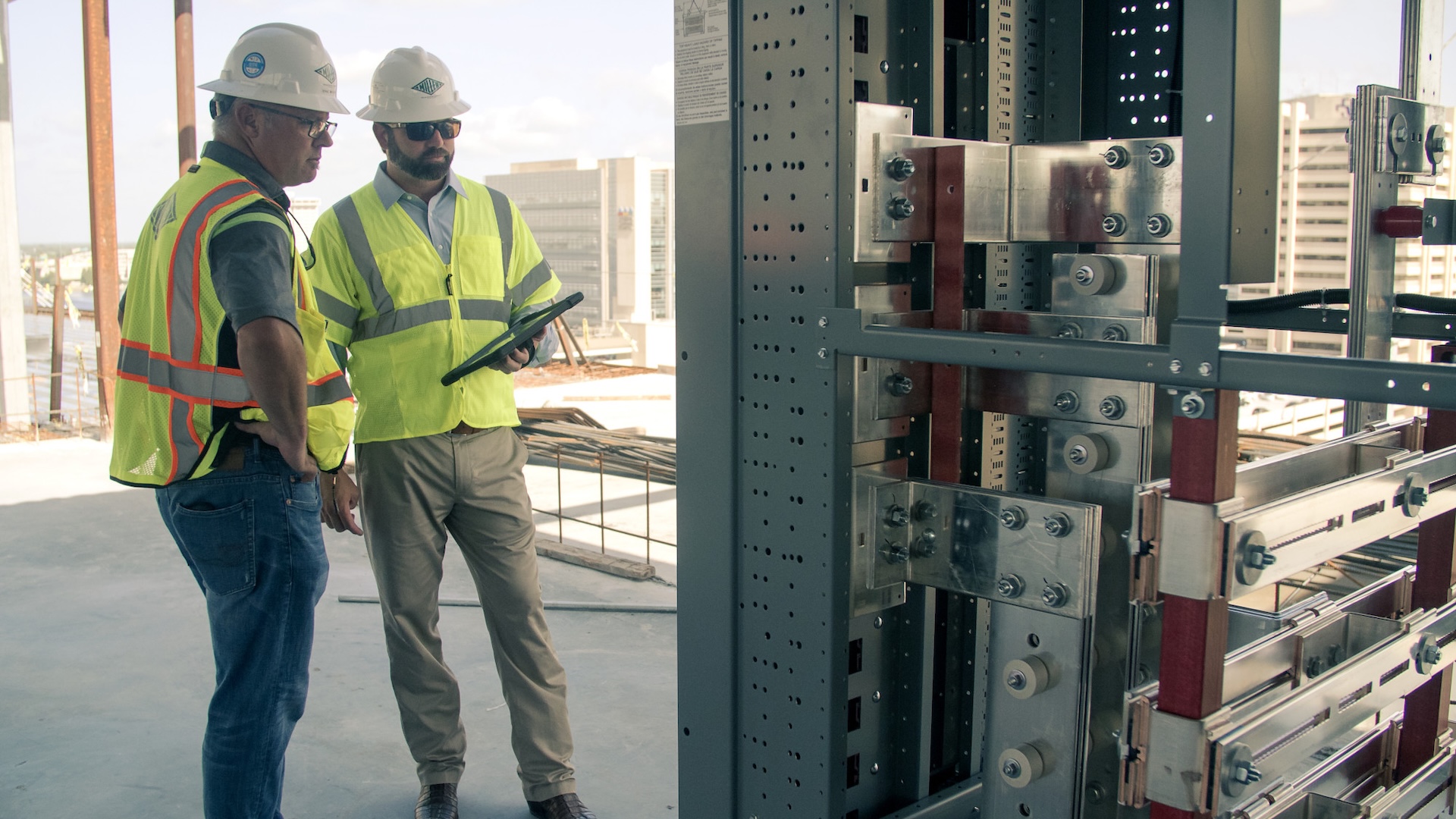 Miller Electric team unloads transformers to provide electrical power for a building, and reviews the Revit model to confirm placement.
